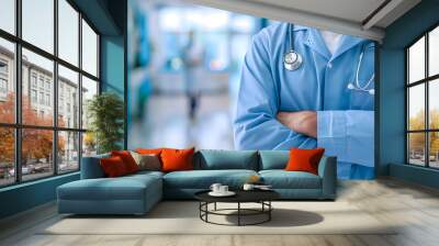 The doctor stood with his arms crossed over his chest and a stethoscope with copy space,In the background is a bright blue hospital. Wall mural