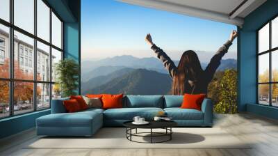 Woman expressing freedom on mountain Wall mural