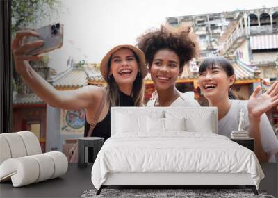 group of multi-ethnic female friends diversity enjoying the city tour. Young tourists having fun in China town. Wall mural