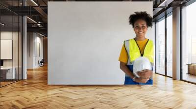 
Portrait of a beautiful female Expert engineer with black African American skin.Attractive woman worker holding hard hat wearing reflective vest with Free,Copy space,  wall,banner,cover,design,PPE. Wall mural