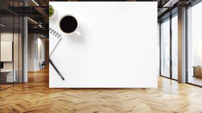 Flat lay, top view office table white desk. Workspace with notepad, pen, green leaf, and coffee cup on white background. Wall mural