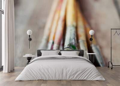 Old artist paintbrushes on rustic wooden table Wall mural