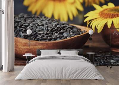 Wooden bowl of sunflower seeds and beautiful yellow sunflowers on background. Wall mural