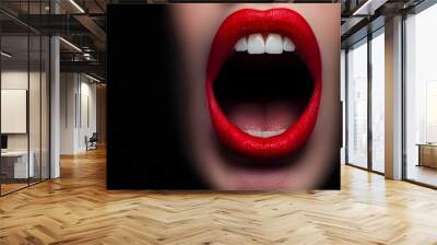 A close-up of a wide-open mouth displaying bright red lips against a dark background, conveying intensity and emotion. Wall mural