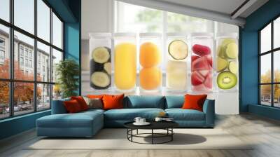 Colorful fruit slices arranged in clear containers on kitchen countertop. Wall mural