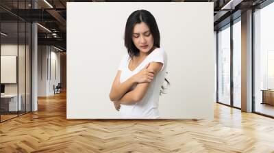 Asian women have skin problems She felt irritation on her skin. Skin infection itching red rash scratching with hands. She around 25 Wearing white shirt standing on isolate background Wall mural