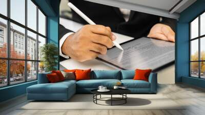 Close up businessman hand electronic Signature on Tablet by Stylus. Write business agreement of contract. Man signing contract on tablet. Business and technology concept. Wall mural