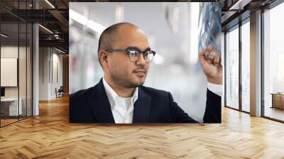 Young asian businessman standing in skytrain. Businessman in urban city travel by sky train. Wall mural