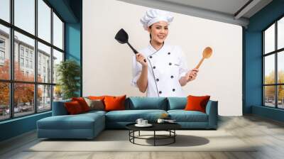 Young beautiful asian woman chef in uniform holding pot ladle utensils cooking in the kitchen various gesture menu good taste on isolated. Cooking woman chef people in kitchen restaurant Wall mural