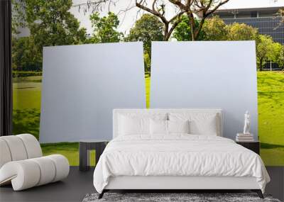 Two empty square white billboards stand in the sun on the green grass of one of Thailand's golf course. Wall mural