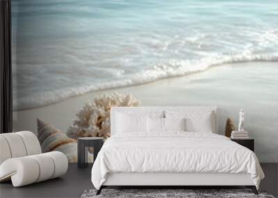 Various seashells placed on white sandy beach with a blue sea as a backdrop, conveys natural beauty and connection to the sea. It can be used in works that wish to convey sense of relaxation, travel Wall mural