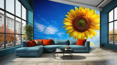 Beautiful sunflower shining under the bright sunshine against a blue sky Wall mural