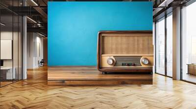 Panoramic vintage radio on wooden table with blue wall Wall mural