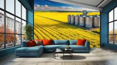 Rapeseed field with yellow flowers and silo in background Wall mural