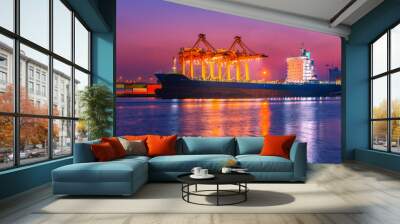 Shipping port. Logistics and transportation of international import export container cargo ship loading or unloading by crane bridge in harbor at twilight dusk morning. Wall mural