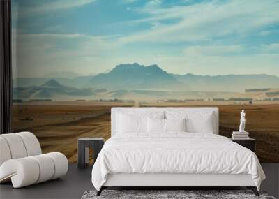 Panoramic photo of the desert, mountains far away, dunes, vast landscape, dusty road with tire tracks Wall mural