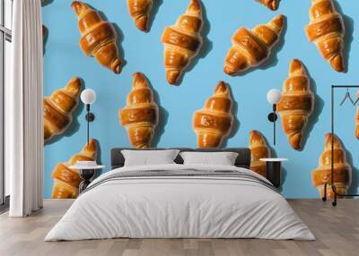 Seamless repeating pattern of croissant on blue background Wall mural