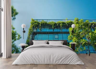 A modern office building surrounded by lush green trees under a clear blue sky.  Wall mural