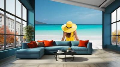 beautiful woman from behind in yellow dress sitting on a tropical beach with white sand and turquoise sea, Concept of summer,vacation,travel. Ai generative Wall mural