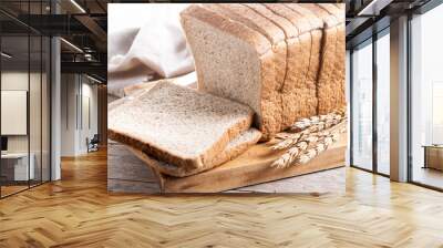 Healthy wholemeal bread slices isolated on wooden table Wall mural