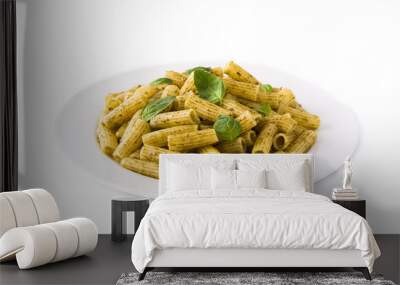 Penne pasta with pesto sauce and basil on a plate, isolated on white background Wall mural