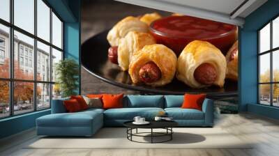 Pigs in blankets. Mini sausages wrapped in puff pastry with ketchup sauce on wooden table Wall mural