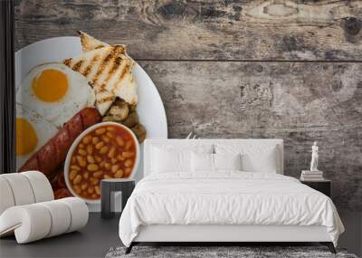 Traditional full English breakfast with fried eggs, sausages, beans, mushrooms, grilled tomatoes and bacon on wooden background.Top view
 Wall mural