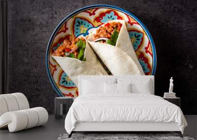 Typical Mexican burrito wrap with beef, frijoles and vegetables on black background. Top view. Copyspace Wall mural