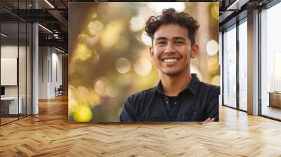 Young, man and portrait of a male laughing in a park for peace, contentment and vitality. Happy, smiling and confident latin person radiating positivity outdoors for peace, happiness and exploration Wall mural