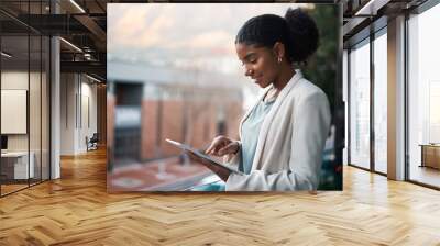 Go digital and get it done today. Shot of a young businesswoman using a digital tablet out on the balcony of a modern office. Wall mural