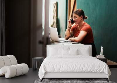 I always follow up on my clients. Cropped shot of an attractive young businesswoman sitting alone and using her cellphone while using her laptop. Wall mural