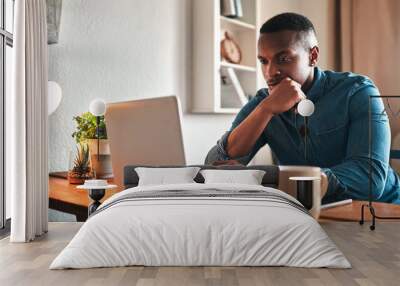 Is this really the best business move. Cropped shot of a handsome young businessman sitting in his home office and looking contemplative while working on his laptop. Wall mural