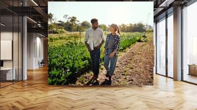 Agriculture manager and farmer meeting, talking and discussing while walking on a farm outside. Planning strategy for harvest season in an eco friendly, organic and sustainable farming industry Wall mural