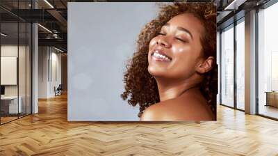 Hair, space and African woman on banner with wind in studio for beauty, wellness and bokeh on grey background. Skincare, smile and happy model face with skin health, glow and relax with luxury mockup Wall mural