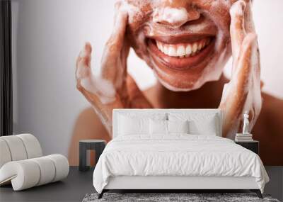 I wash my face twice a day. Studio shot of an unrecognizable woman washing her face against a white background. Wall mural