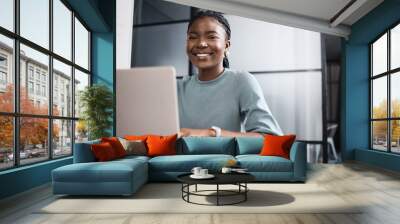 It takes determination, and I know it. Portrait of a young businesswoman working on a laptop in an office. Wall mural