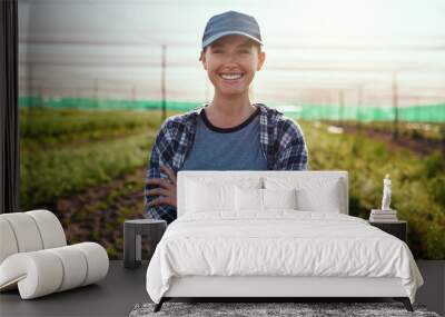 Life on the farm is awesome. Cropped portrait of an attractive young female farmer standing with her arms crossed while working on the farm. Wall mural