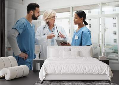 Quality healthcare is all about putting the patient at the centre. Shot of a group of medical practitioners having a discussion in a hospital. Wall mural