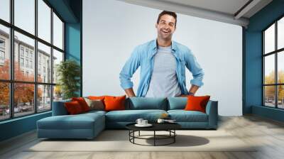 Ready to take on the day. Portrait of a cheerful young man smiling brightly while standing against a grey background. Wall mural