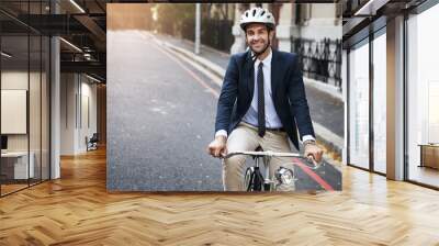 Safety first. Shot of a handsome young businessman riding his bicycle to work in the morning. Wall mural