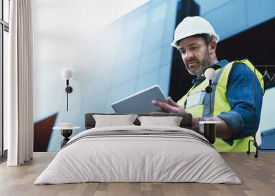 This software help me to keep track of everything. Shot of a engineer using a digital tablet on a construction site. Wall mural