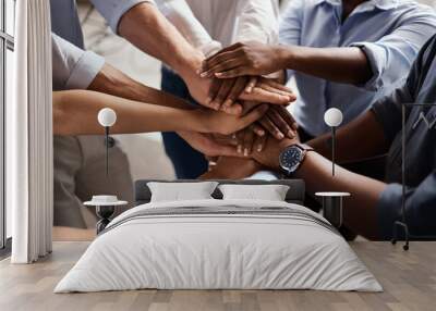 Were in this together. Shot of a group of unrecognizable businesspeople stacking their hands at work. Wall mural