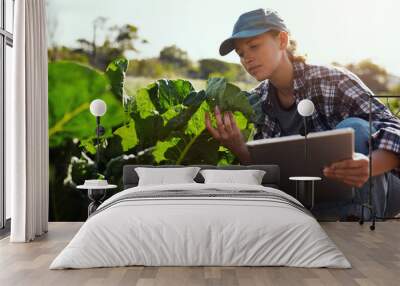 You're looking nice and strong. Cropped shot of an attractive young female farmer using a tablet while working on her farm. Wall mural