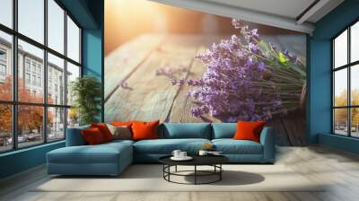 A bouquet of lavender tied with twine, resting on a rustic wooden table with sunlight streaming in Wall mural