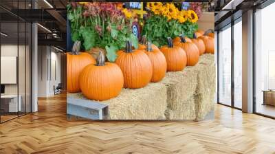 A rustic fall pumpkin display at a local market, with vibrant orange pumpkins and hay bales Wall mural