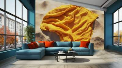 A yellow beach towel on the sand Wall mural