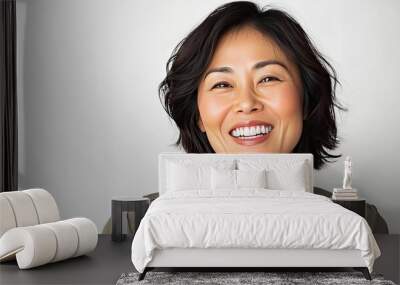 Asian woman in her 30s or 40s, smiling with joy and gladness, with a clean white background Wall mural