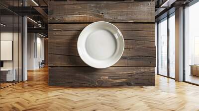 Minimalist empty white plate on a rustic wooden table, top view. Space for text or food presentation. Wall mural