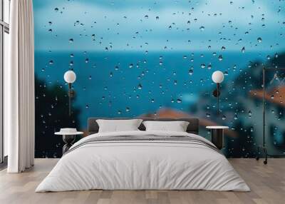 Rain drops on a window, with a view of the sea blurred in the background Wall mural