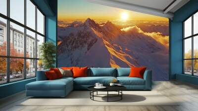 top view of snow-covered mountain peaks, with the sun rising over the horizon, casting a golden glow over the landscape Wall mural